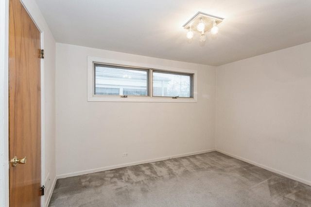 spare room with baseboards and carpet
