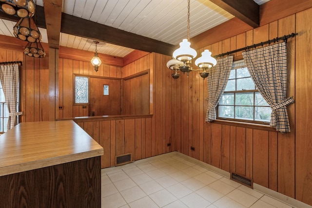 6624 N Kenneth Ave, Lincolnwood, IL 60712 - unfurnished dining area with an inviting chandelier, wood walls, beam ceiling, and visible vents