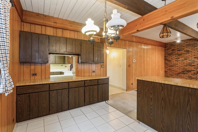 kitchen featuring light countertops, light colored carpet, a chandelier, and beam ceiling