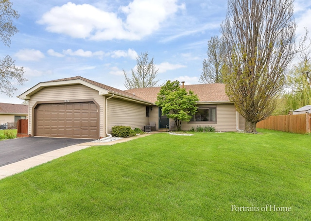 ranch-style house with roof with shingles, fence, an attached garage, driveway, and a front yard