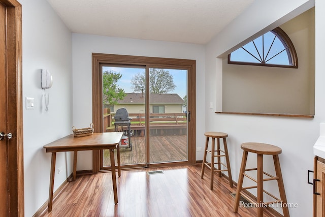 entryway with baseboards, light wood finished floors, and visible vents