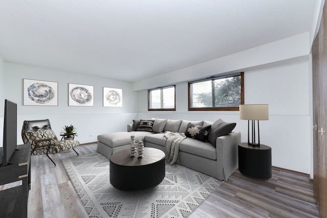 living area with light wood-style flooring and baseboards