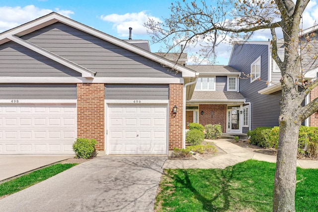 view of front of property with brick siding, driveway, and a garage
