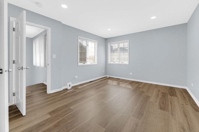 empty room featuring baseboards, recessed lighting, and wood finished floors