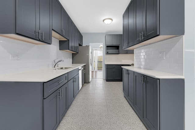 kitchen with a sink, light countertops, tasteful backsplash, and dishwasher