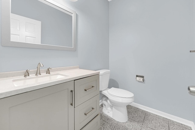 half bath featuring baseboards, vanity, and toilet
