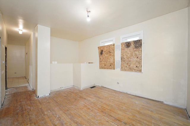 unfurnished room with visible vents and hardwood / wood-style flooring