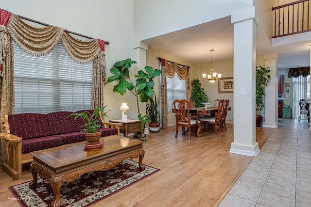 living room with a chandelier, decorative columns, and a wealth of natural light