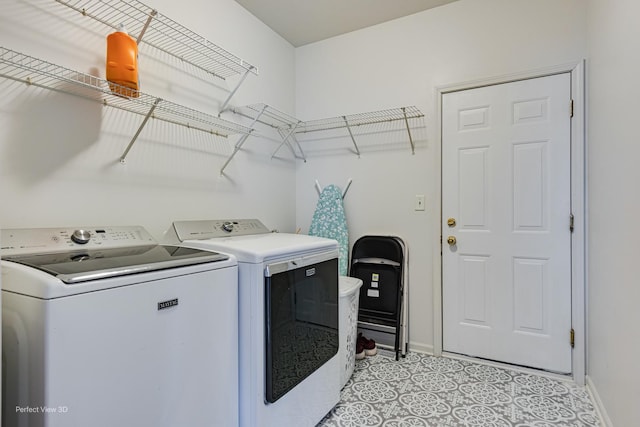 laundry room featuring baseboards, laundry area, and washing machine and dryer