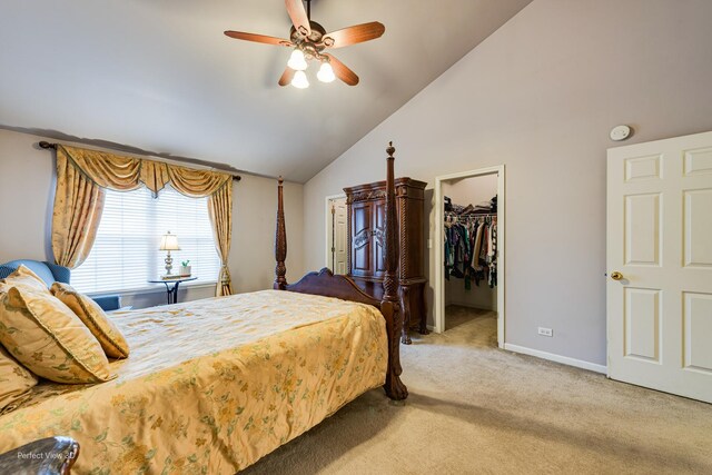 bedroom with a closet, vaulted ceiling, ceiling fan, carpet flooring, and a walk in closet