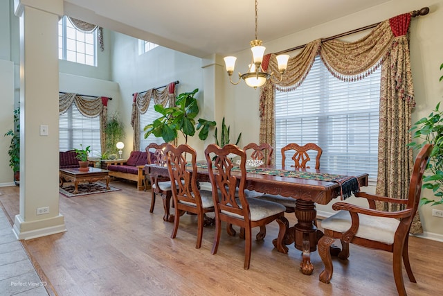 dining area with wood finished floors, a chandelier, and baseboards