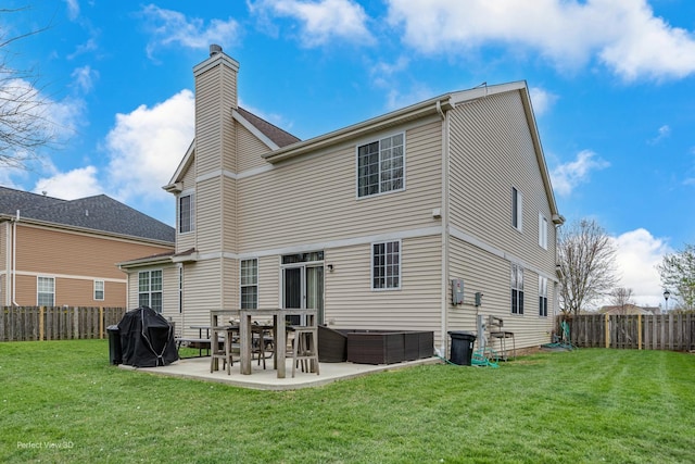 rear view of property featuring a patio, a chimney, a fenced backyard, and a yard
