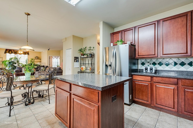 kitchen with light tile patterned flooring, dark countertops, and a kitchen island