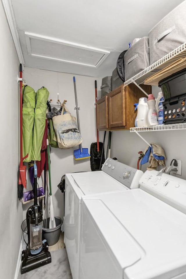 laundry room with attic access, washing machine and clothes dryer, and cabinet space