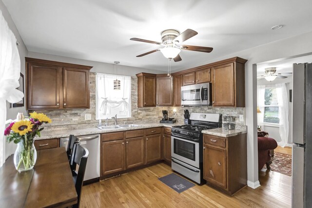 kitchen featuring ceiling fan, stainless steel appliances, backsplash, and a sink