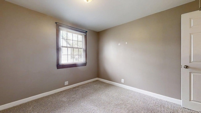 spare room featuring carpet flooring and baseboards