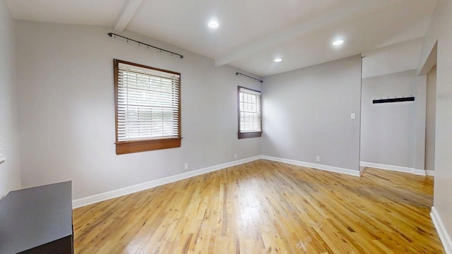 empty room with light wood-style flooring, baseboards, and vaulted ceiling with beams