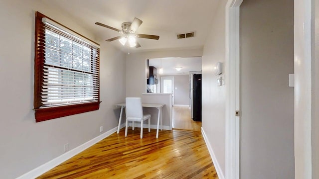 dining room with light wood-style floors, visible vents, baseboards, and ceiling fan