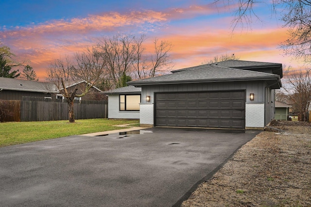 530 Thompson Ave, Winthrop Harbor, IL 60096 - view of front of home featuring aphalt driveway, roof with shingles, fence, a yard, and brick siding