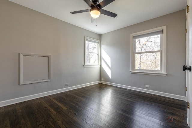 spare room with ceiling fan, dark wood-style floors, and baseboards