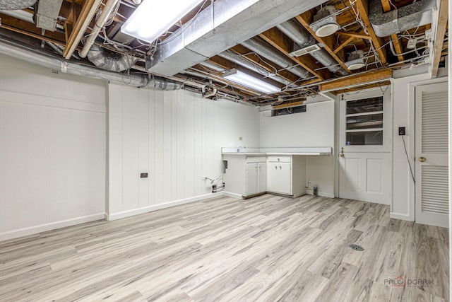finished basement with baseboards and light wood finished floors