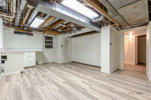 unfinished basement with light wood-type flooring and baseboards