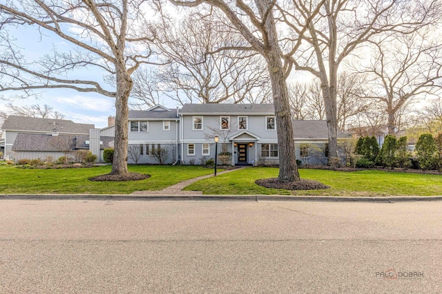 colonial-style house featuring a front lawn