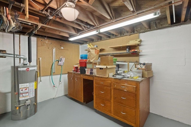 unfinished basement with water heater, a workshop area, and concrete block wall