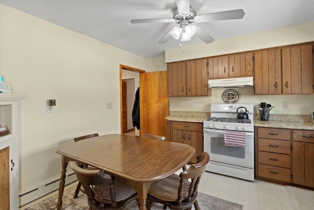 kitchen with a baseboard radiator, white gas range oven, under cabinet range hood, light countertops, and brown cabinets