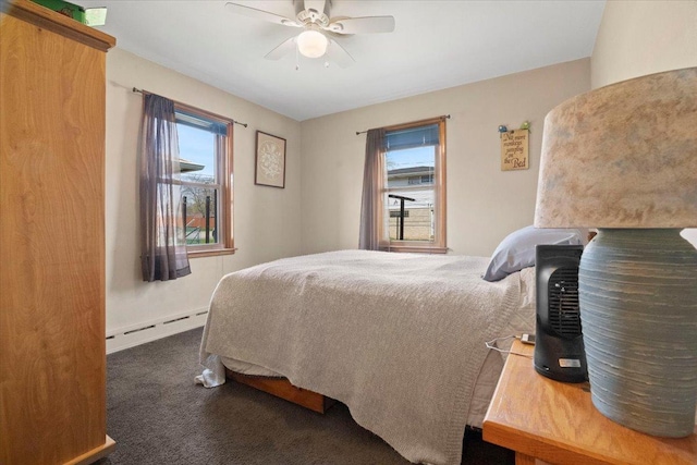 carpeted bedroom featuring a baseboard heating unit, multiple windows, and ceiling fan