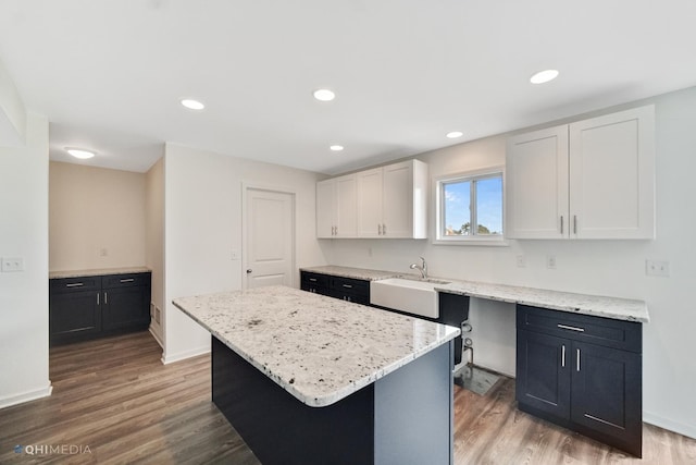 814 English St, Braidwood, IL 60408 - kitchen with light stone countertops, a sink, white cabinetry, and wood finished floors