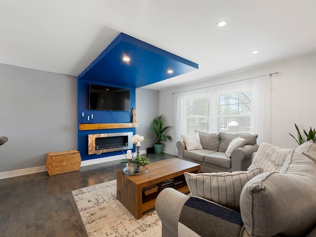 living area featuring recessed lighting, baseboards, a glass covered fireplace, and hardwood / wood-style flooring