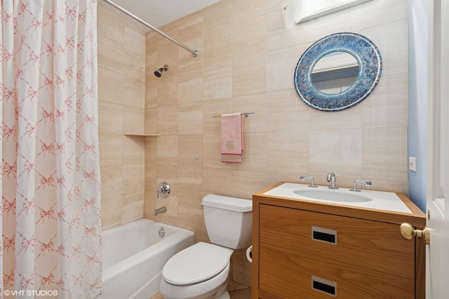 bathroom featuring tile walls, toilet, shower / bathtub combination with curtain, and vanity