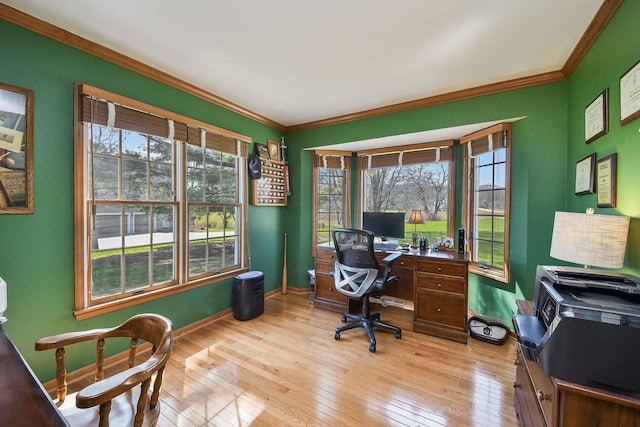 office space with baseboards, ornamental molding, and light wood-style floors