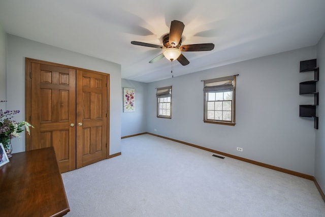 unfurnished bedroom featuring baseboards, visible vents, and light colored carpet