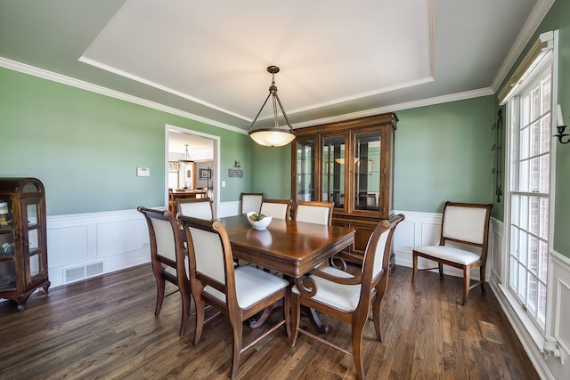 dining room with dark wood-style floors, visible vents, wainscoting, and a tray ceiling