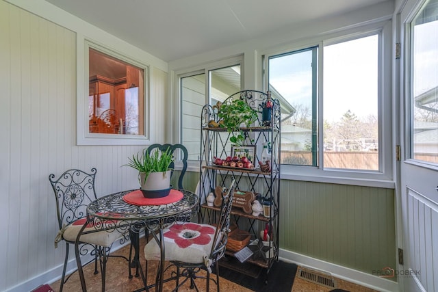 sunroom / solarium with wooden walls, visible vents, and baseboards