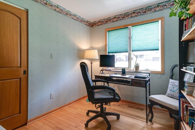 office area featuring baseboards and light wood finished floors