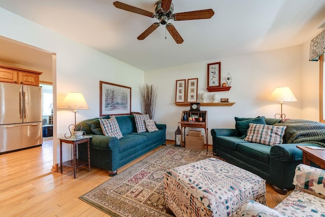 living room featuring light wood-style floors and a ceiling fan