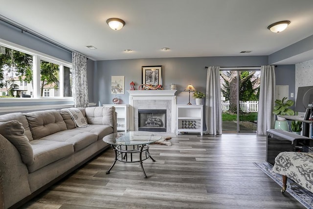 living room with visible vents, wood finished floors, and a tile fireplace