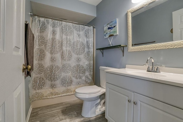 bathroom with vanity, wood finished floors, toilet, and curtained shower