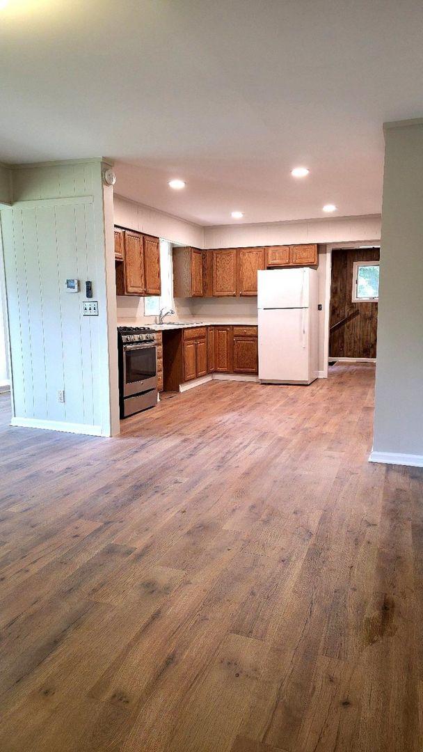618 Princeton Rd, Depue, IL 61322 - kitchen with freestanding refrigerator, stainless steel gas stove, brown cabinets, dark wood finished floors, and recessed lighting