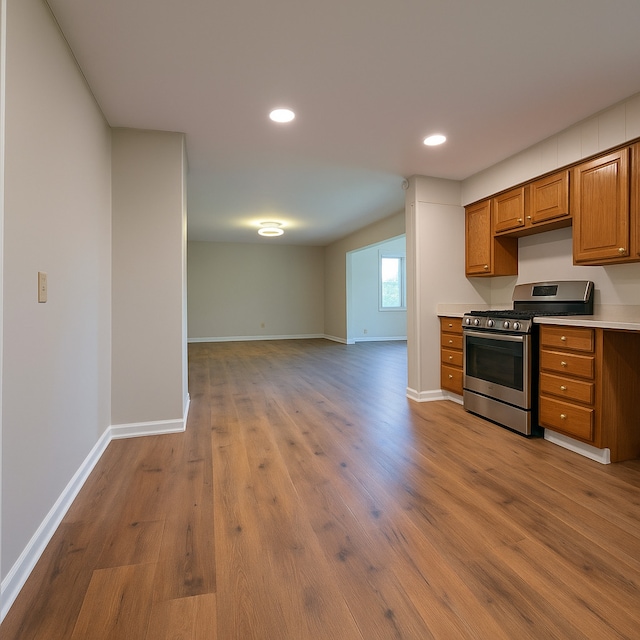 618 Princeton Rd, Depue, IL 61322 - kitchen with gas range, brown cabinets, open floor plan, wood finished floors, and light countertops