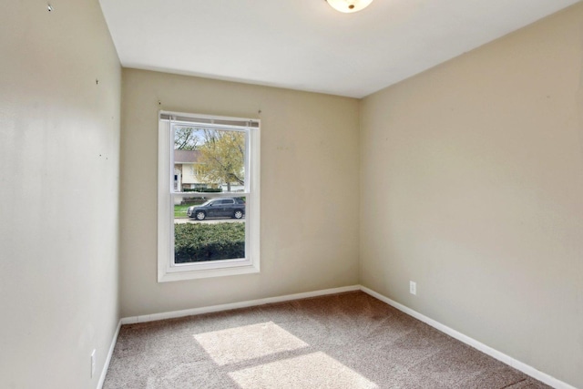 spare room featuring baseboards and carpet flooring