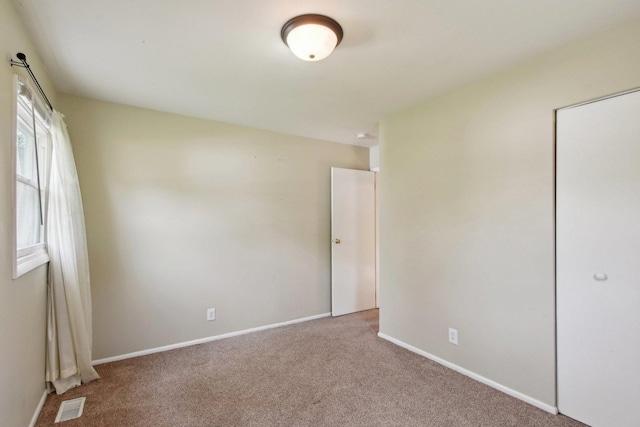 empty room with visible vents, baseboards, and carpet floors