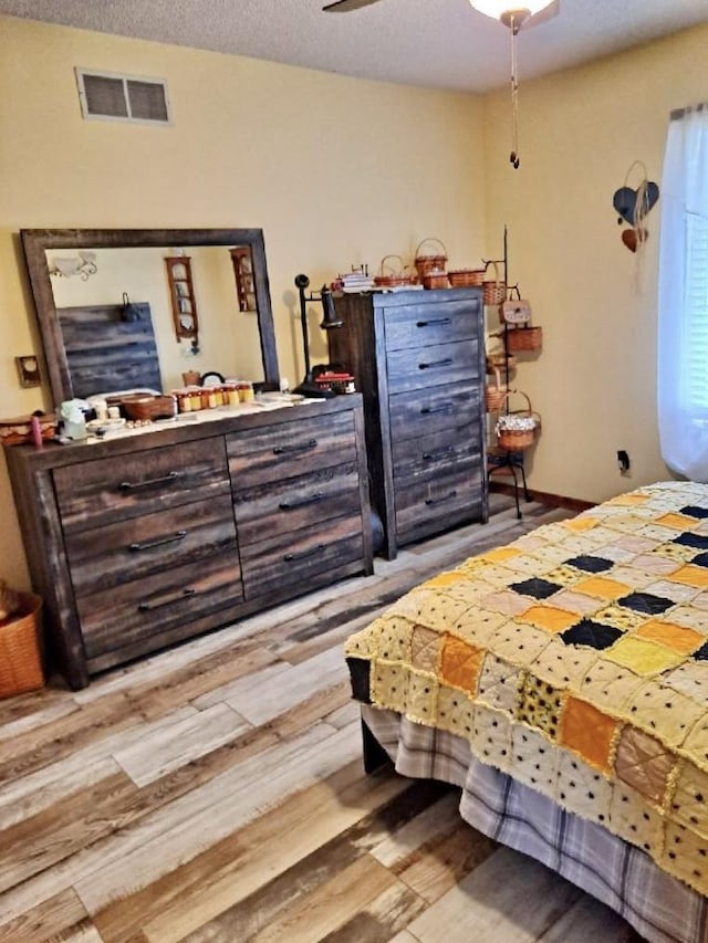 bedroom with visible vents and wood finished floors