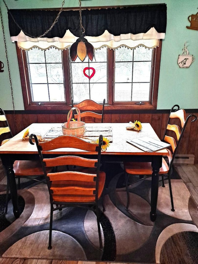 dining room with wood walls and wainscoting