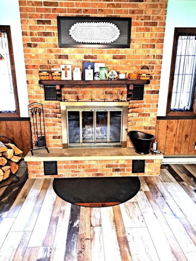 room details with a fireplace, wood finished floors, wood walls, and visible vents