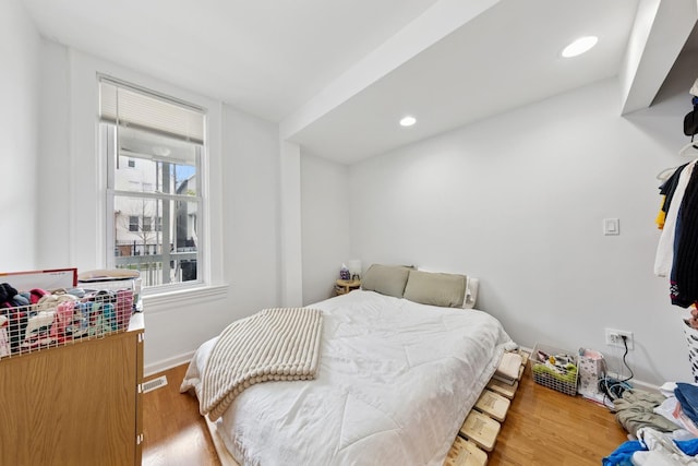 bedroom with recessed lighting, baseboards, visible vents, and wood finished floors