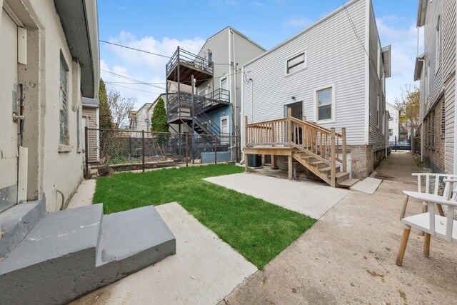 rear view of house featuring a yard, a fenced backyard, and a patio area